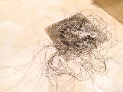 Mechones de cabello acumulados en la coladera de la regadera