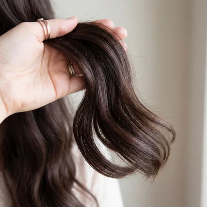 Mano sosteniendo un mechón de cabello largo